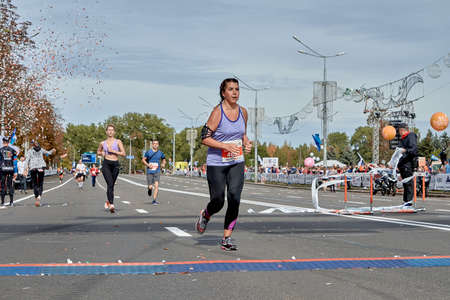 September 15, 2019 Minsk Belarus A marathon race in which a young woman runs to the finish line on a city roadのeditorial素材