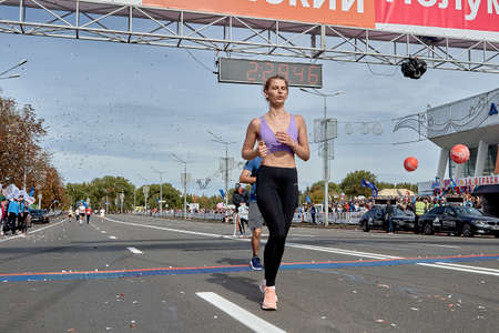 September 15, 2019 Minsk Belarus A female athlete crossed the finish line of the marathon on a city roadのeditorial素材