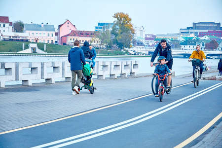 October 19, 2019 Minsk Belarus A family on bicycles rides along a bike path along the riverのeditorial素材