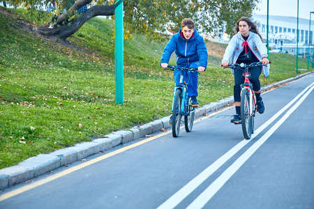 October 19, 2019 Minsk Belarus A guy and a girl on bicycles ride a bike pathのeditorial素材