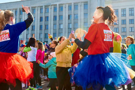 March 8, 2019 Minsk Belarus Women's Day Race on March 8 A crowd of beautiful happy girls in carnival holiday costumes dancing at a street concert.Girls shoot each other on the phone.のeditorial素材