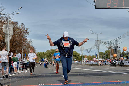September 15, 2019 Minsk Belarus A marathon race in which an active participant crosses the finish line with their hands raisedのeditorial素材