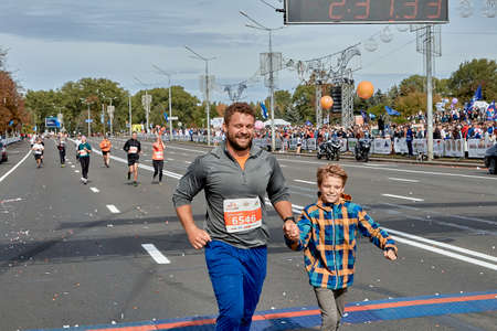 September 15, 2019 Minsk Belarus Happy father and son cross the finish line of the half marathon in Minskのeditorial素材