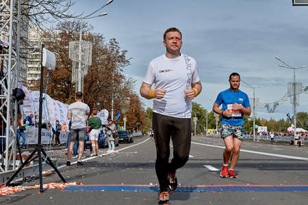 September 15, 2019 Minsk Belarus An athlete crosses the finish line of a marathon on a city roadのeditorial素材