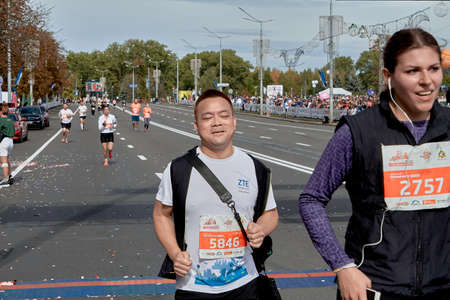 September 15, 2019 Minsk Belarus Close up of a happy man and woman crossing the finish line of a marathon on a city roadのeditorial素材