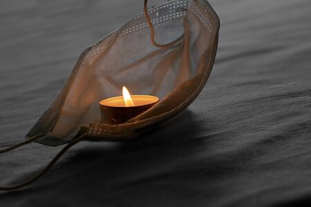 The candle flame is burning in a protective medical maskの写真素材