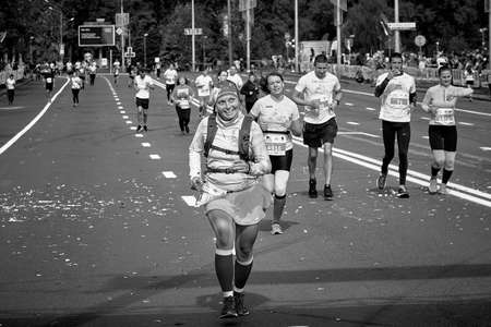September 15, 2019 Minsk Belarus In black and white, an active, happy woman runs a city road marathonのeditorial素材