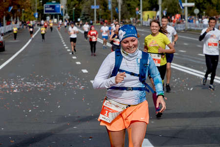 September 15, 2019 Minsk Belarus A marathon race in which a close-up of an active, happy woman runs along a city roadのeditorial素材