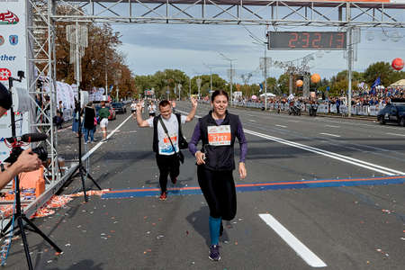 September 15, 2019 Minsk Belarus A marathon race in which a happy man his hands raised and woman cross the finish line on a city roadのeditorial素材
