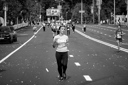 September 15, 2019 Minsk Belarus In a black-and-white photo, a woman runs along the city road of the half marathon in Minsk.Healthy lifestyleのeditorial素材