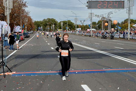 September 15, 2019 Minsk Belarus An active woman crosses the finish line of a marathon on a city roadのeditorial素材