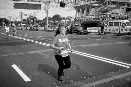 September 15, 2019 Minsk Belarus In a black and white image, a happy woman crosses the finish line of a marathonのeditorial素材