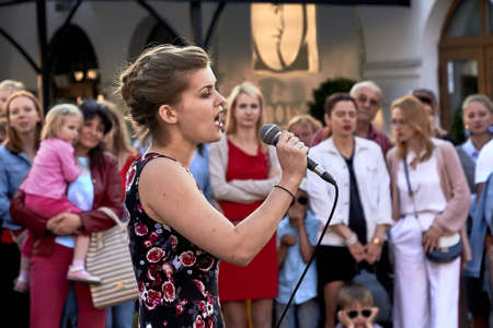 May 25, 2019 Minsk Belarus Close up of a young woman with a microphone singing in front of a crowd of peopleのeditorial素材