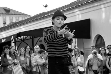 May 25, 2019 Minsk Belarus In black and white, girl actress in striped clothes shows theatrical performance with a red ball to the music at the street. Front viewのeditorial素材