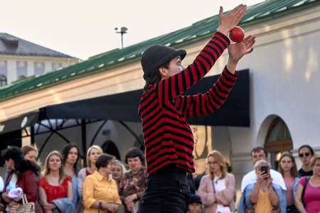 May 25, 2019 Minsk Belarus Girl actress in mime costume and makeup shows theatrical performance with a red ball at the street.のeditorial素材