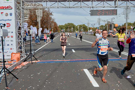 September 15, 2019 Minsk Belarus Minsk hosts a half-marathon where happy participants cross the finish line with their phones in their handsのeditorial素材