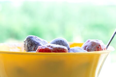 Close-up of strawberries covered with sour cream and cream on a blurry background . Healthy dietの写真素材