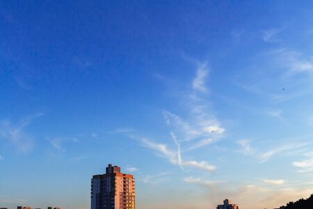 Evening orange blue sky with clouds over the cityの写真素材