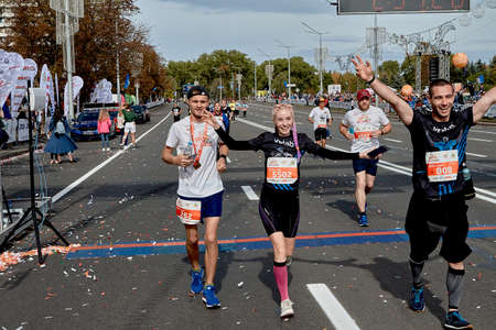 September 15, 2019 Minsk Belarus A half-marathon is being held in Minsk, where happy athletes celebrate crossing the finish line with their hands raised.のeditorial素材