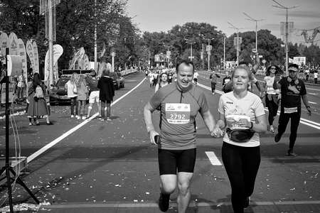 September 15, 2019 Minsk Belarus Black and white image.Close up of a happy man and woman crossing the finish line hand in handのeditorial素材
