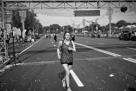September 15, 2019 Minsk Belarus In a black-and-white image, an active woman crossed the finish line of the marathon in Minskのeditorial素材