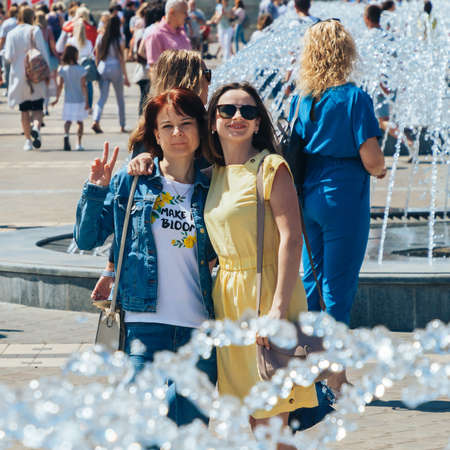 June 23, 2019 Minsk Belarus Two friends are standing next to the fountainsのeditorial素材