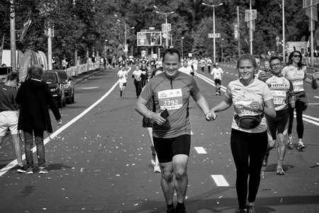 September 15, 2019 Minsk Belarus Black and white image.Close up of a pair of happy marathon runners running hand in hand ahead of the participantsのeditorial素材