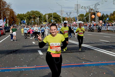 September 15, 2019 Minsk Belarus The half marathon is held in Minsk, a happy woman celebrates crossing the finish line with her hands raised.のeditorial素材