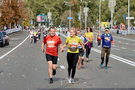 September 15, 2019 Minsk Belarus A couple of marathon runners run hand in hand along a city roadのeditorial素材