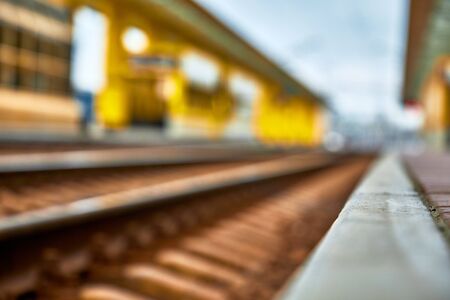 A railway platform and rails. Railway station in blur.Shallow depth of field.の写真素材