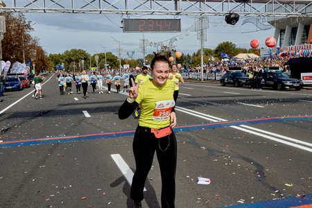September 15, 2019 Minsk Belarus The half marathon is held in Minsk, a happy woman celebrates crossing the finish line with a raised hand.のeditorial素材