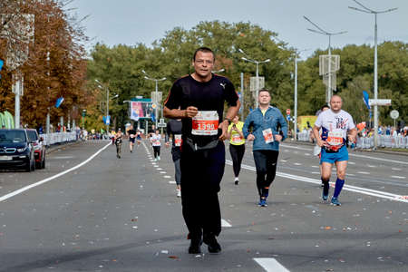 September 15, 2019 Minsk Belarus A marathon race in which a Mature participant in glasses runs along a city roadのeditorial素材