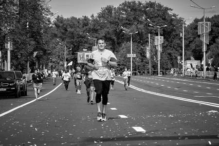 September 15, 2019 Minsk Belarus In the black-and-white image, Minsk hosts a half-marathon in which an athlete runs along a city roadのeditorial素材