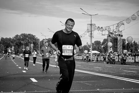 September 15, 2019 Minsk Belarus Black and white image. A marathon race in which a close-up of a happy Mature participant in glasses runs along the roadのeditorial素材