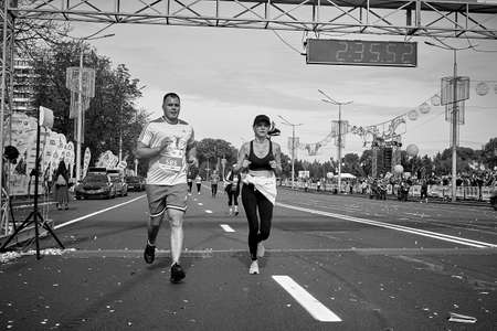 September 15, 2019 Minsk Belarus Black and white image. Minsk hosts a half-marathon where a couple crosses the finish lineのeditorial素材
