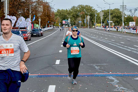September 15, 2019 Minsk Belarus An active woman crosses the finish line of a marathon on a city roadのeditorial素材