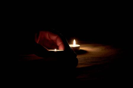 There is a man who puts a burning candle on the table on memorial dayの写真素材