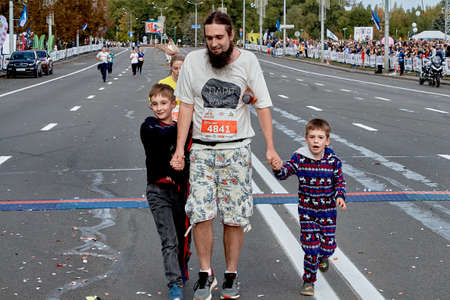 September 15, 2019 Minsk Belarus A marathon race in which an athlete with a beard and two young sons crosses the finish lineのeditorial素材
