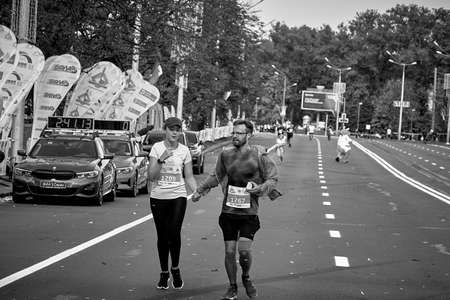 September 15, 2019 Minsk Belarus A marathon race in which an active man and woman run holding handsのeditorial素材