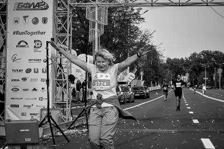 September 15, 2019 Minsk Belarus Close-up of a woman celebrating crossing the finish line of a marathon with her hands raisedのeditorial素材