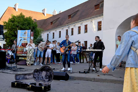 June 1, 2019 Minsk Belarus Close-up of a hipster musician with glasses, playing an acoustic guitar, standing on the street in the eveningのeditorial素材
