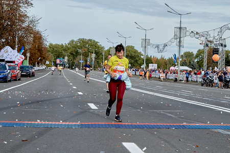 September 15, 2019 Minsk Belarus There a woman crosses the finish line of a marathonのeditorial素材