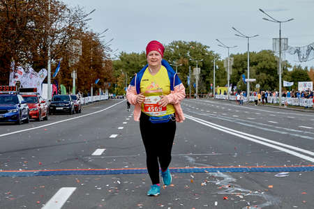 September 15, 2019 Minsk Belarus Minsk hosts a half marathon where a plump woman crosses the finish line on a city roadのeditorial素材