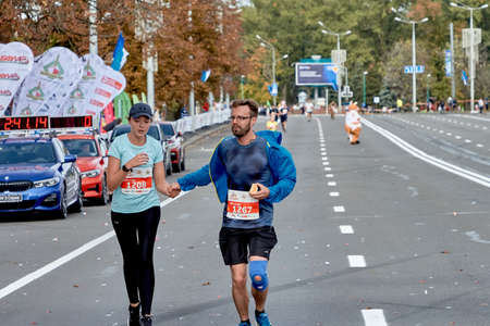 September 15, 2019 Minsk Belarus A marathon race in which a close - up of an active man and woman running holding handsのeditorial素材