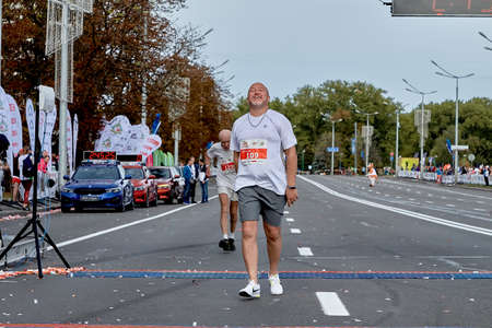September 15, 2019 Minsk Belarus A happy participant crosses the finish line of the marathonのeditorial素材
