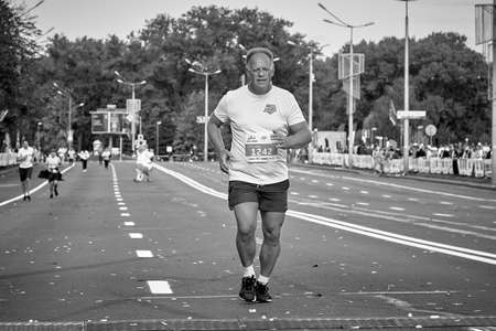 September 15, 2019 Minsk Belarus In black and white, a marathon race in which an aged athlete runs to the finish lineのeditorial素材