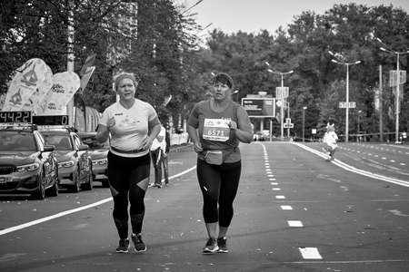 September 15, 2019 Minsk Belarus In a black-and-white image, a half-marathon is taking place in Minsk, where two Mature women run along a city roadのeditorial素材