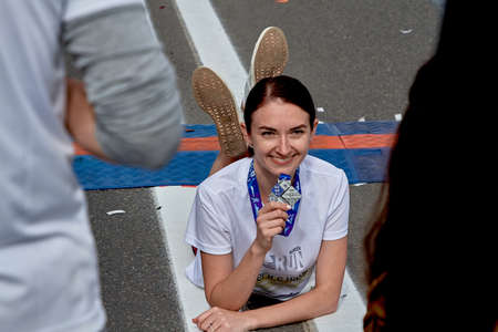 September 15, 2019 Minsk Belarus There is a happy woman with a medal lying on the roadのeditorial素材