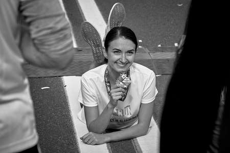 September 15, 2019 Minsk Belarus There is a happy woman with a medal lying on the road.Black and white imageのeditorial素材