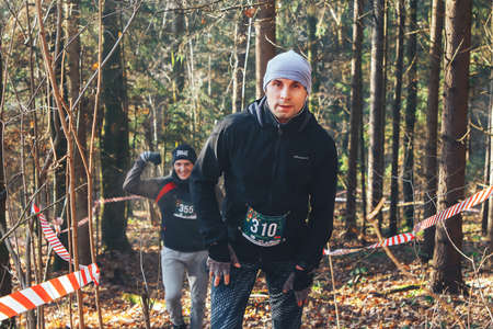 November 17, 2018 Logoisk Belarus Beetle-trail 8 LOGOISK Two happy athletes run up a mountain in the woodsのeditorial素材